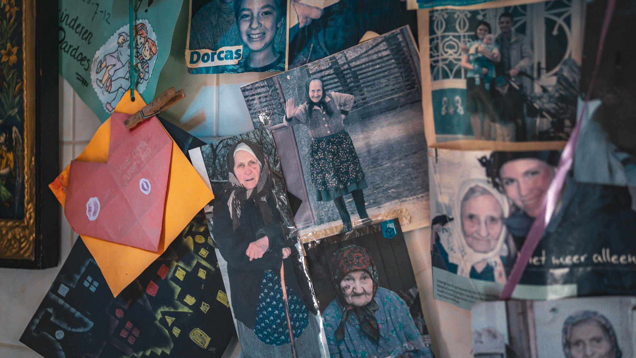 Verschillende oude en nieuwe foto's van mensen, inclusief portretten en groepsfoto's, op een prikbord met Dorcas-logo, herinneringen en verhalen verzamelen.