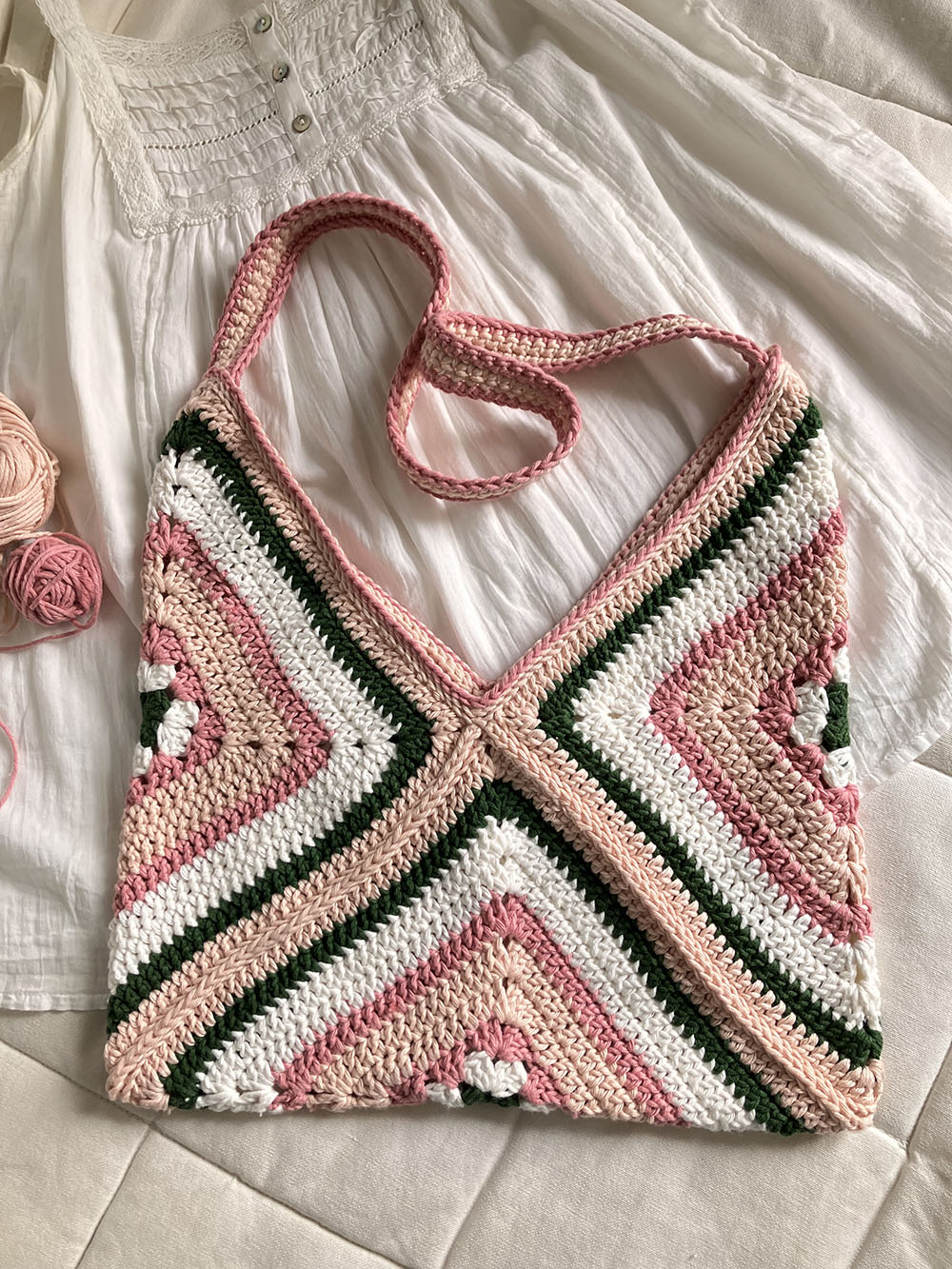 Vrolijk gehaakte tasje met geometrisch patroon in roze, wit, Groen en beige, perfect voor een zomerse dag.